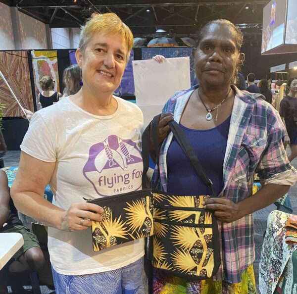 Gracie Kumbi, artist from Merrepen Arts and Felicity Wright from Flying Fox Fabrics. Gracie is holding a Delia bag made from hand printed fabric in her Sand Pam design
