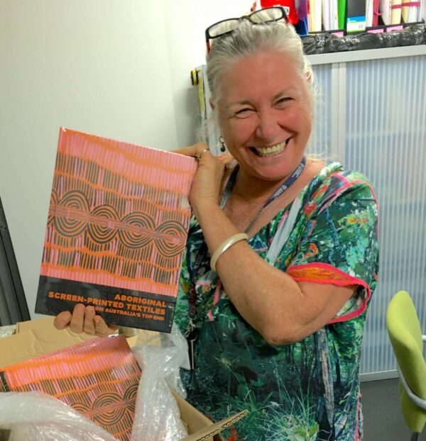 Dr Joanna Barrkman holding a copy of Aboriginal Screen-Printed Textiles from Australias Top End a book catalogue of the Fowler Museum UCLA exhibition of the same. name